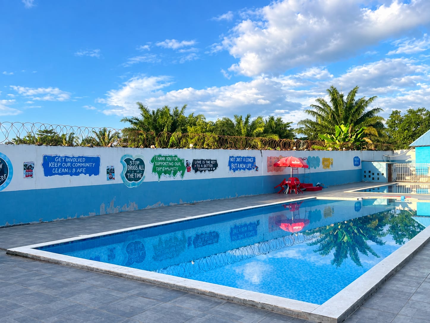 Pool and palm trees at Pool Palace Hotel And Resort in Ganta, Liberia